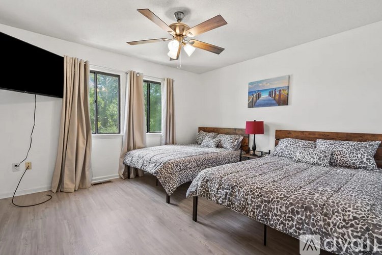A bedroom with two beds and a ceiling fan.