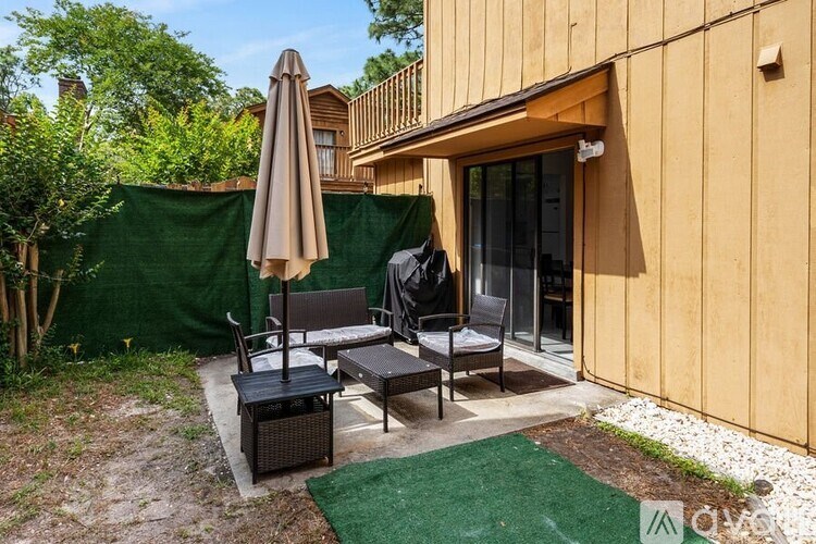 A patio with a table and chairs is set up outside a house.