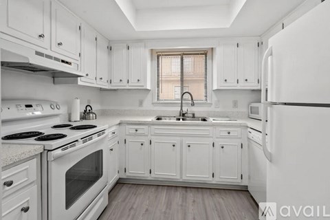 A kitchen with white cabinets and appliances.