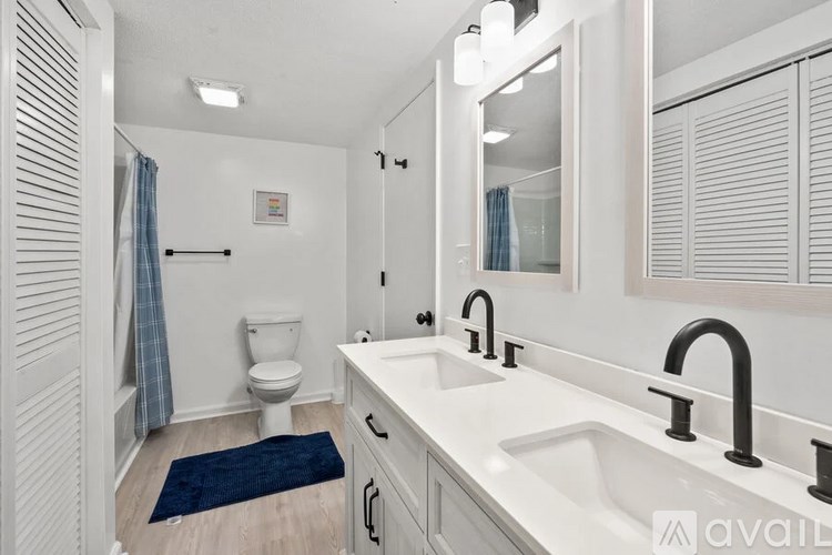 A bathroom with a toilet, sink, and mirror.