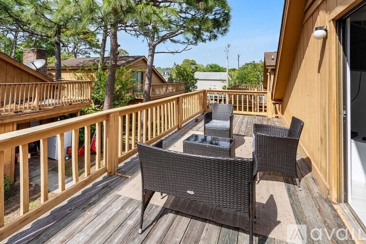 A balcony with a table and chairs overlooking a tree.
