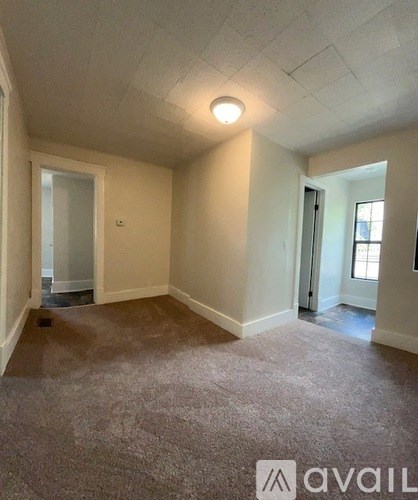 A room with carpeted floor and white walls.