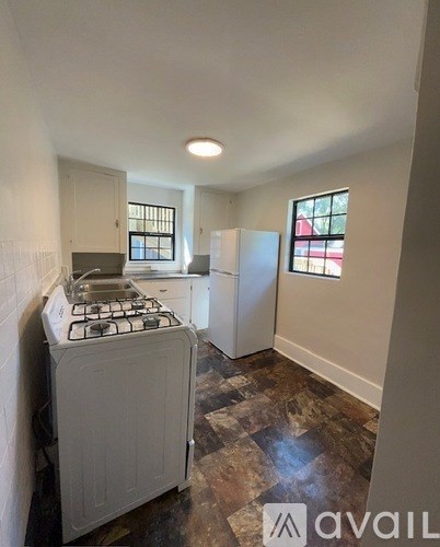 A kitchen with a stove, sink, and refrigerator.