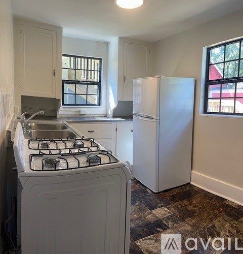 A kitchen with a white stove and a white refrigerator.