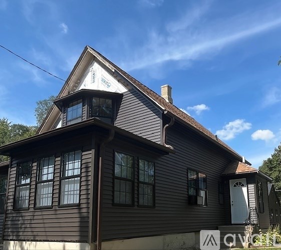 A house with a brown siding and a white door.