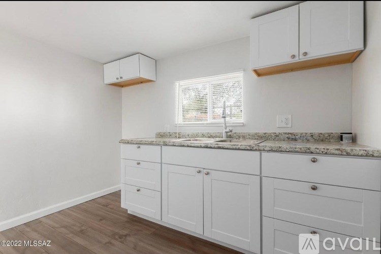 A kitchen with white cabinets and a granite countertop.