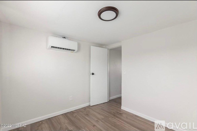 A room with a white door and a wall-mounted air conditioner unit.