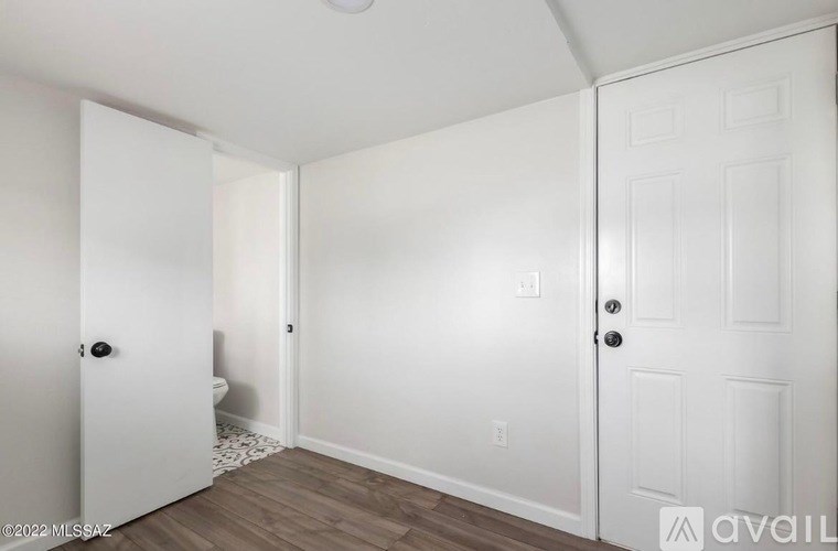 A white door is on the left and a white door with a black handle is on the right.