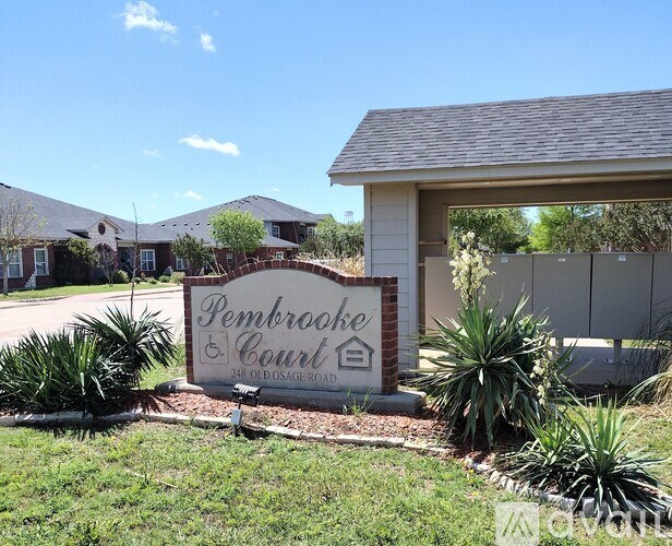 A sign for Pembrooke Court is in front of a building.
