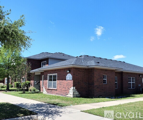 A red brick house with a white door and windows.