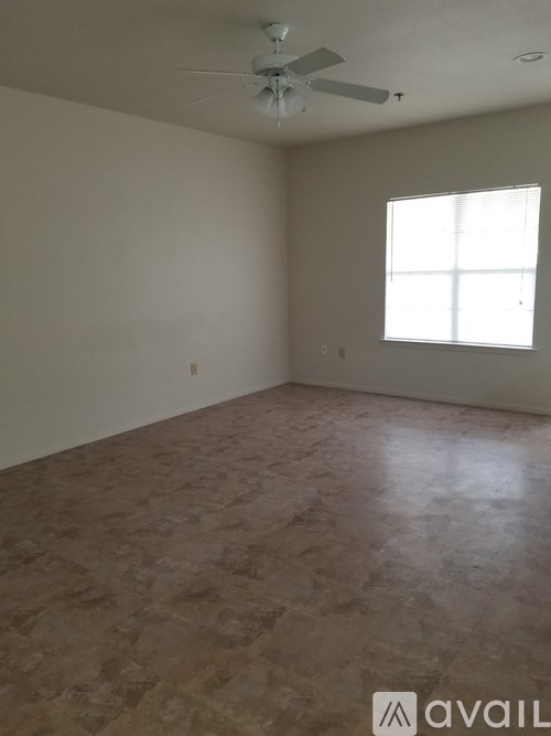 A room with a ceiling fan and a window.