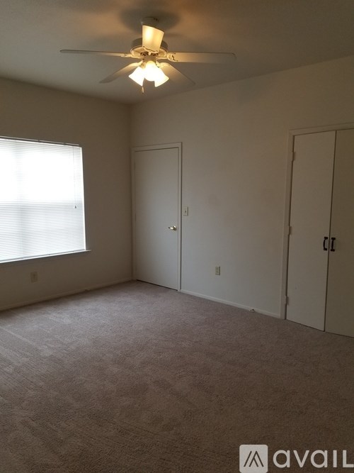 A room with a ceiling fan and two doors.