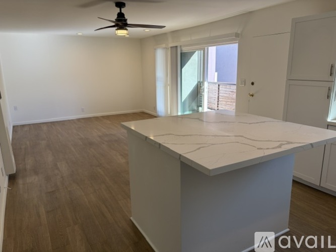A kitchen with wooden floors and a white island.