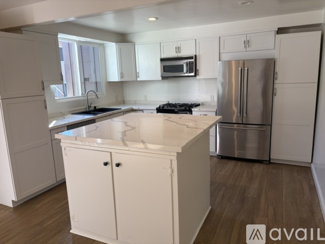 A kitchen with a wooden floor and grey cabinets.