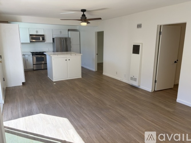 A kitchen with a marble countertop and wooden flooring.