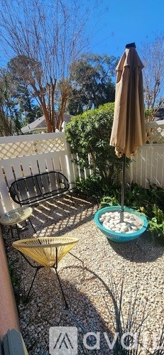 A patio with a table, chairs, and an umbrella.