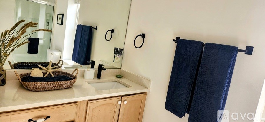 A bathroom with a sink, mirror, and towel rack.