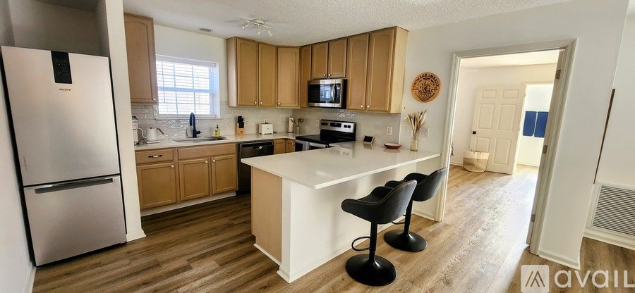 A kitchen with a white refrigerator and wooden cabinets.