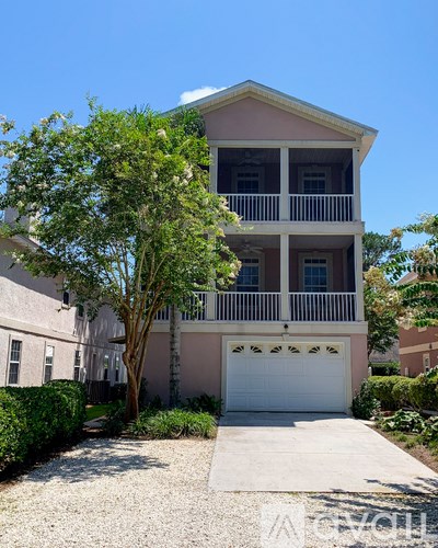 A two-story house with a white garage door and a balcony on the second floor.