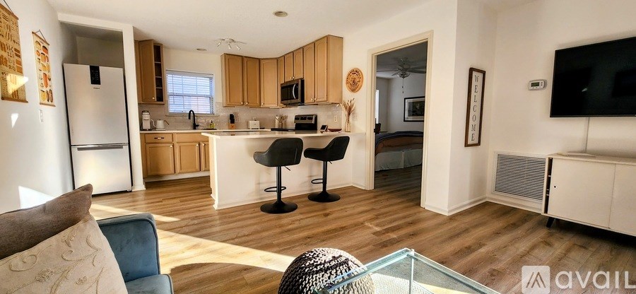A kitchen with a bar stool and a fridge.