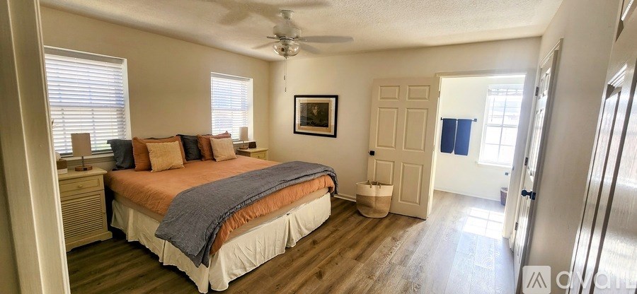 A bedroom with a bed, dresser, and window.