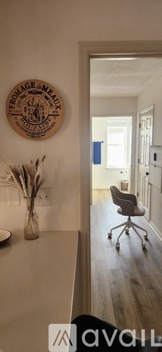 A wooden plaque with the word "Farmhouse" written on it hangs on a wall above a kitchen counter.