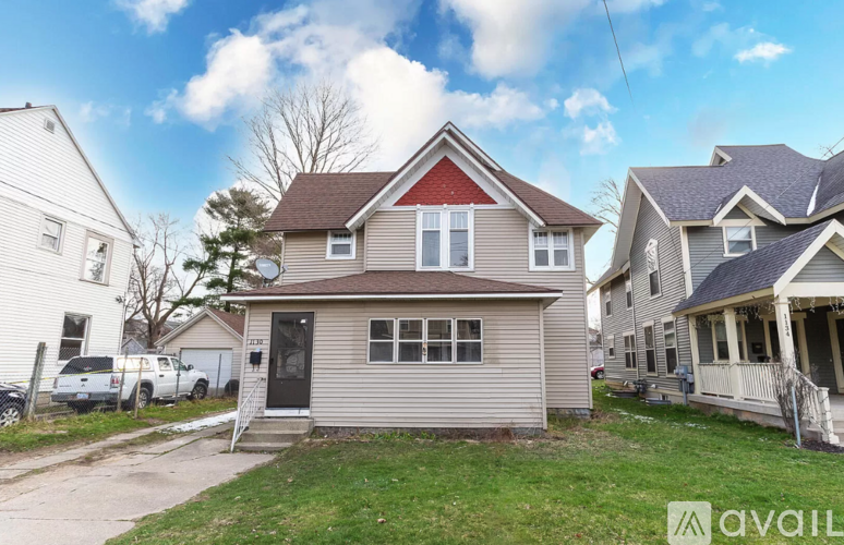 A house with a red roof is for sale.