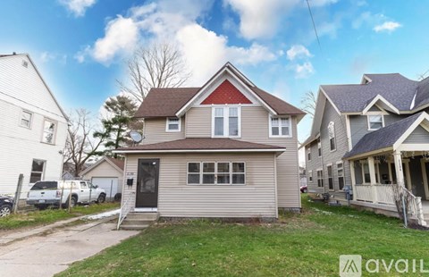 A house with a red roof is for sale.
