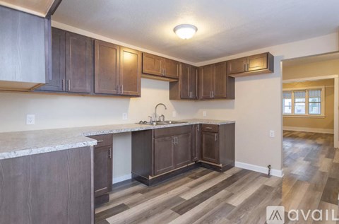 A kitchen with brown cabinets and a marble countertop.