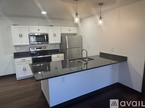 A kitchen with white cabinets and a black countertop.