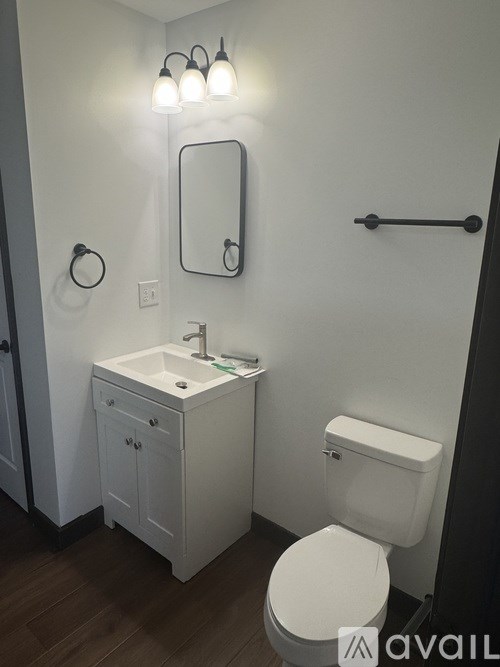 A white toilet sits next to a sink in a bathroom.