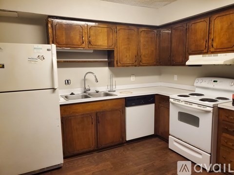 A kitchen with wooden cabinets and white appliances.
