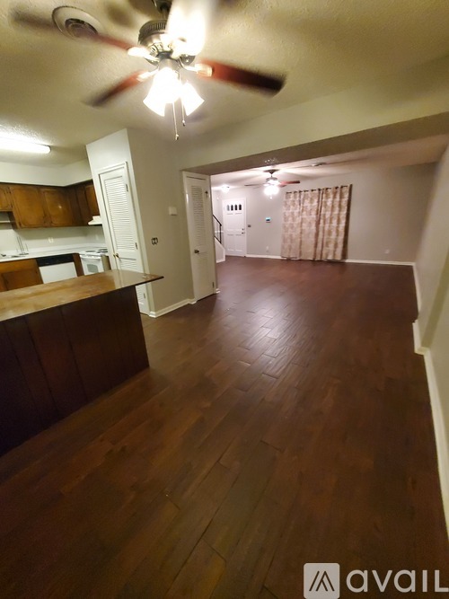 A room with wooden floors and a ceiling fan.
