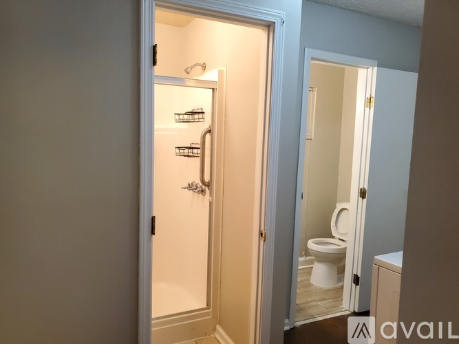 A white door with a glass window is open to a bathroom.