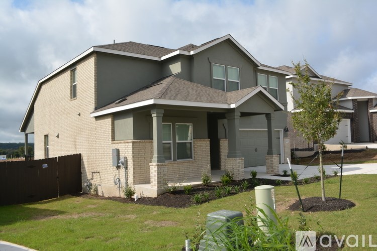 A house with a brown fence and a tree in front.