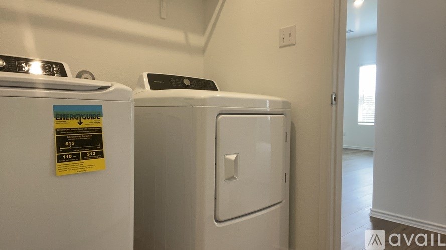 A yellow EnerGuide sticker is on the side of a white dryer.