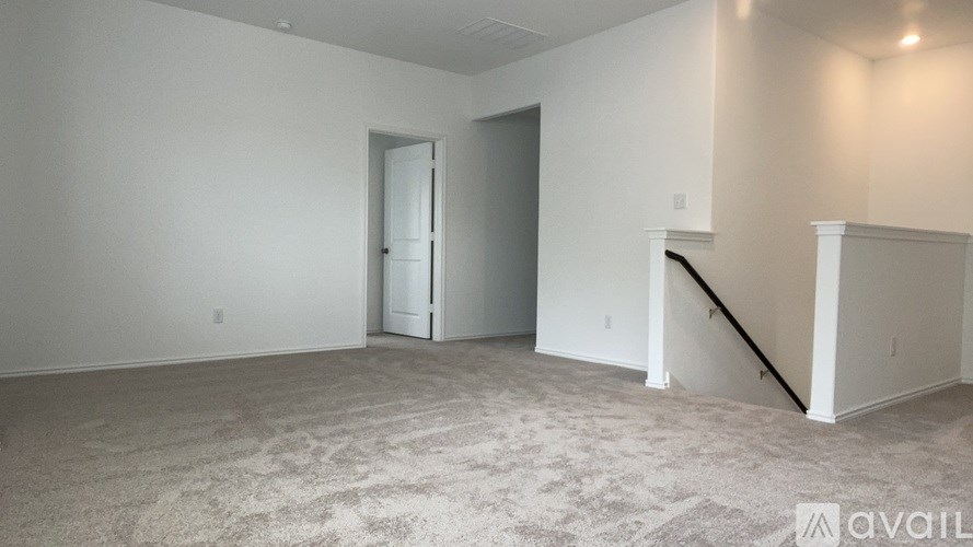 A spacious room with a carpeted floor and two doors.