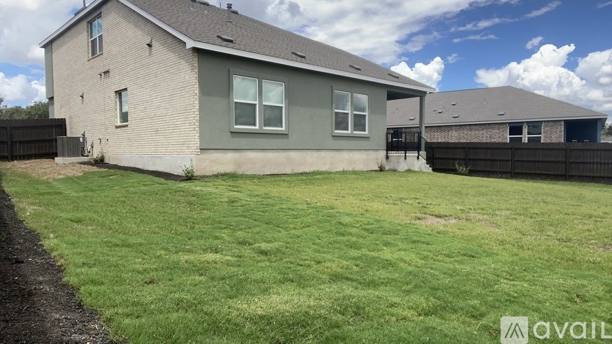 A house with a grey roof and a green lawn in front.