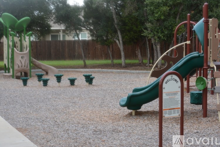 A playground with a green slide and a sign that says "Welcome".