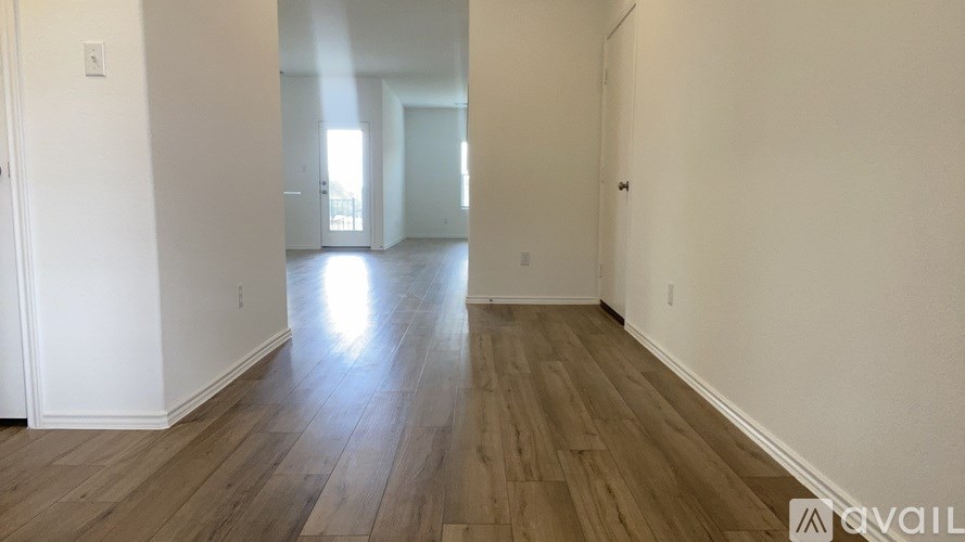 A room with wooden flooring and white walls.