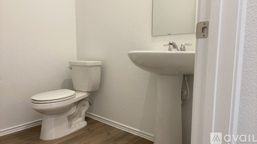 A white toilet and sink in a small bathroom.