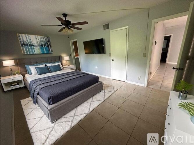 A bedroom with a large bed and a ceiling fan.