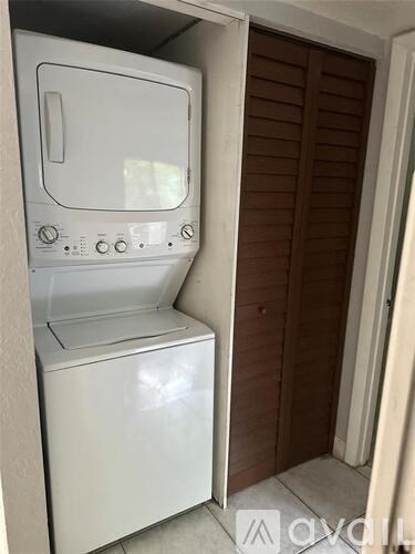 A white dishwasher is placed in a small kitchen.