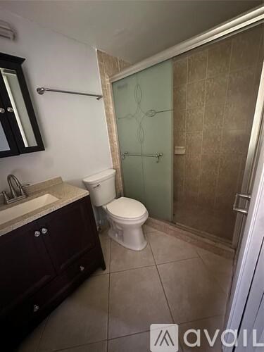 A bathroom with a toilet, sink, and shower.