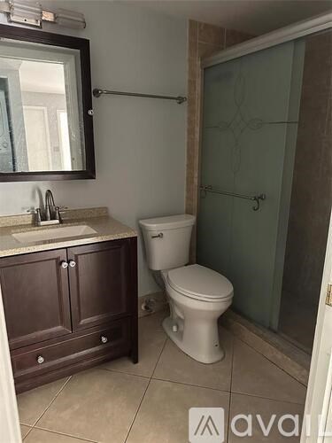 A bathroom with a toilet, sink, and shower.