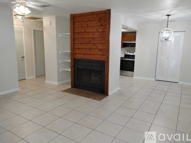 A living room with a fireplace and a ceiling fan.