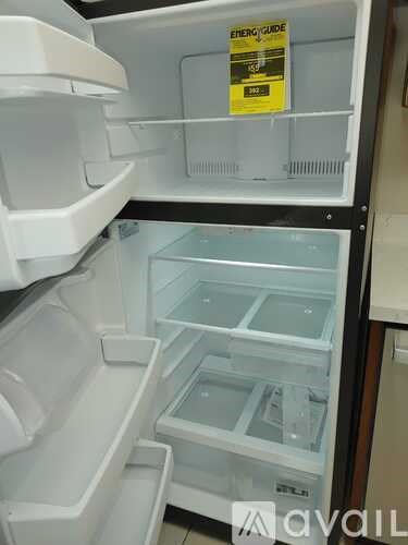 A white refrigerator with a yellow sign on the door.