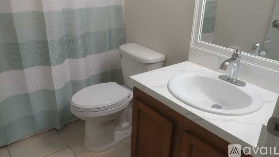 A white toilet sits next to a white sink in a bathroom.