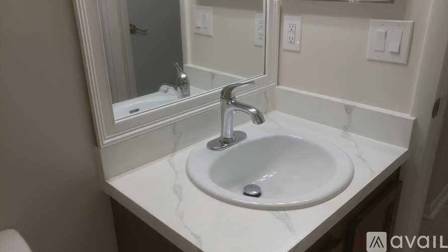A white sink with a silver faucet is in a bathroom.