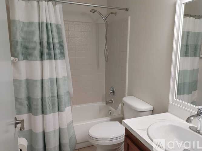 A bathroom with a toilet, sink, and shower.